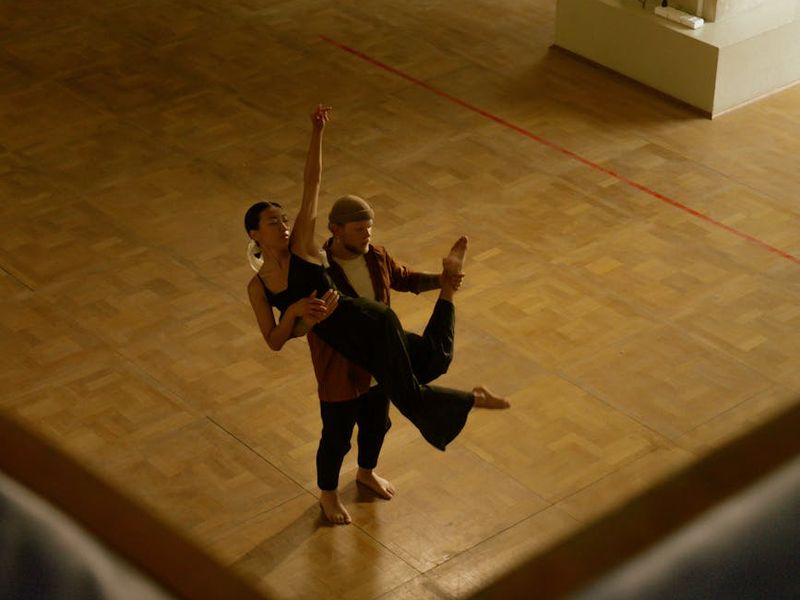 A focused man performing a steady lifting movement outdoors